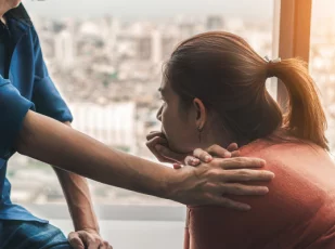 врач держит девушку за плечо